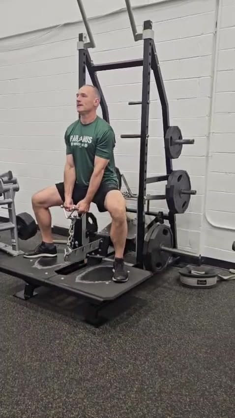 A client filmed mid-set on a landmine squat