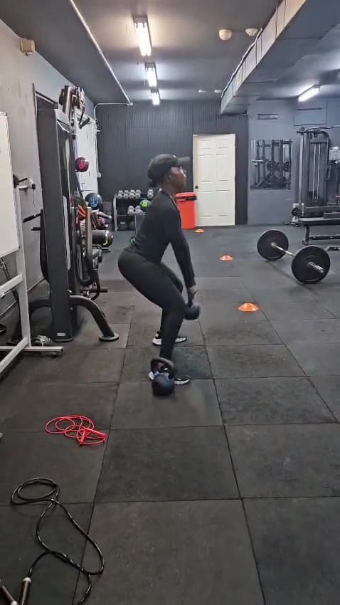A client setting up a kettlebell swing