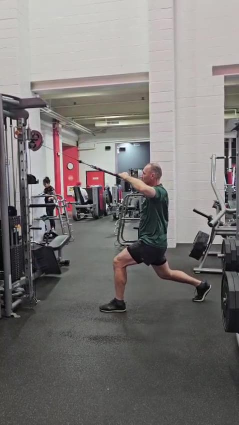 A client holding a lunge on the gym floor