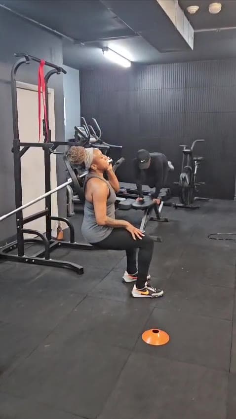 A client resting at the squat rack between sets