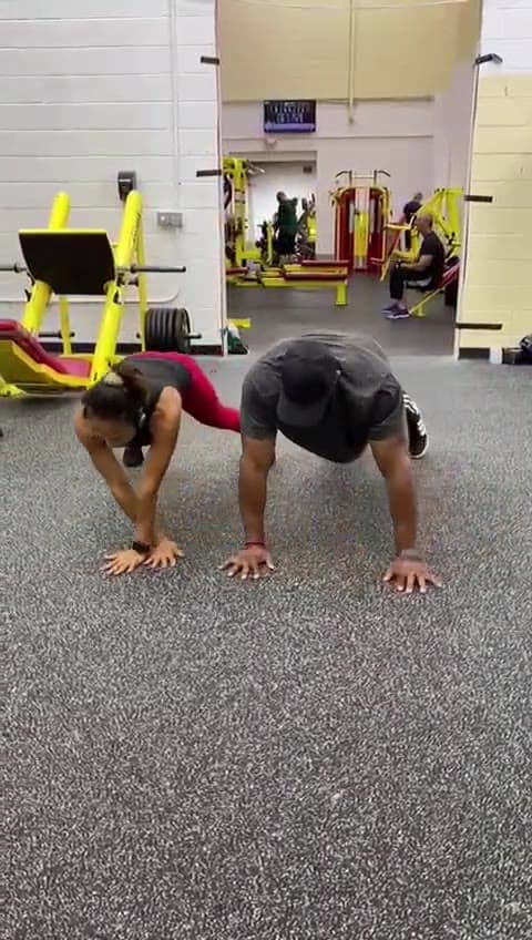 Daine Chang on the floor beside a client, running through a drill together