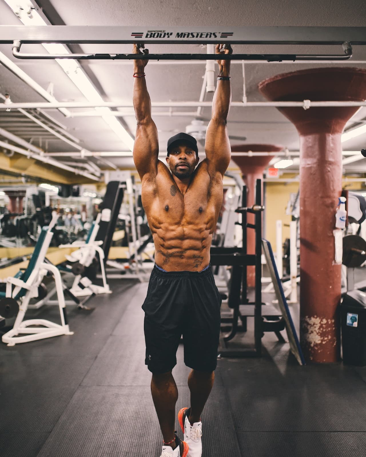 Daine Chang hanging from a pull-up bar in a gym