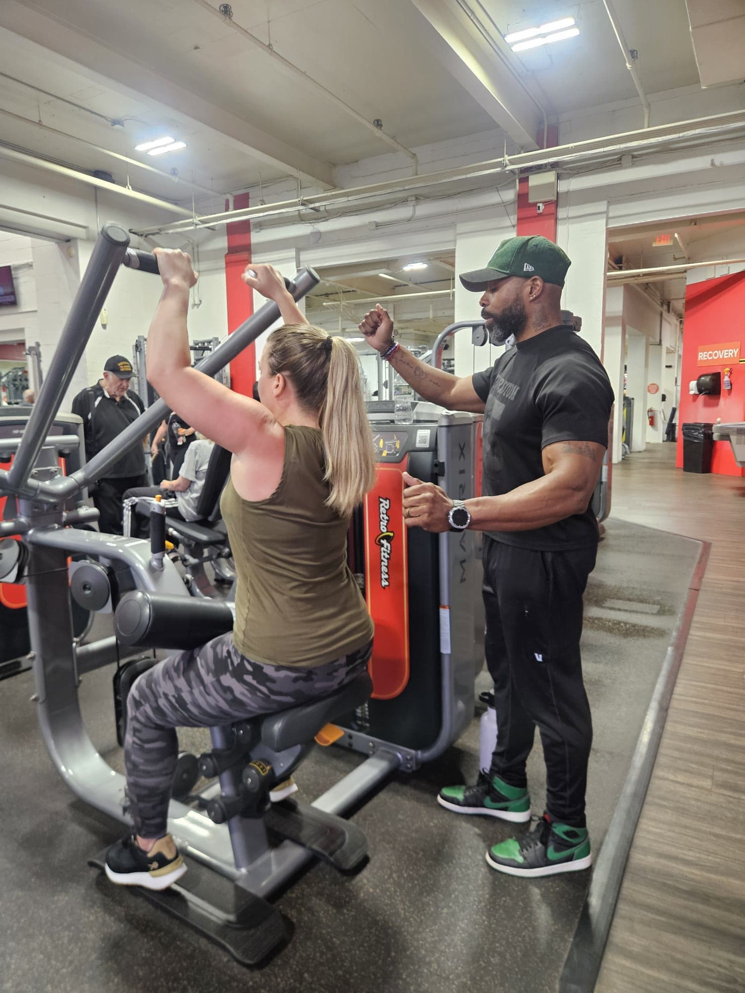 Daine Chang cueing a client at the top of a lat pulldown
