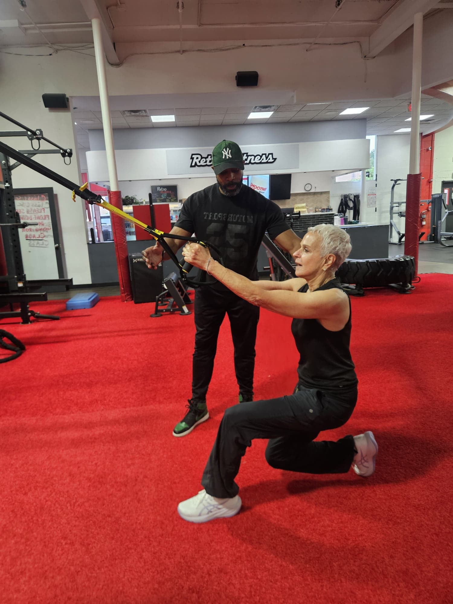 Daine Chang spotting a client through a suspension-strap lunge